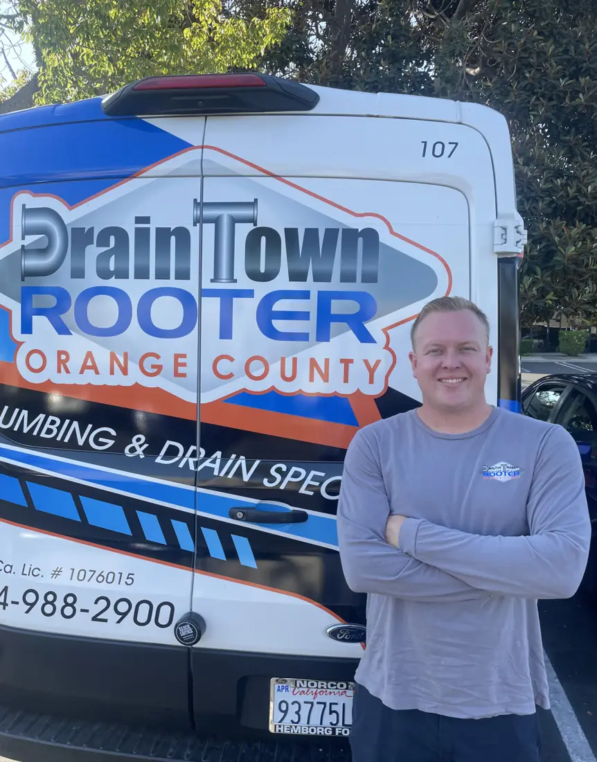 Drain Town Rooter team member standing next to a company van