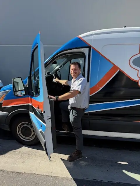 Drain Town Rooter technician in the open door of a company van